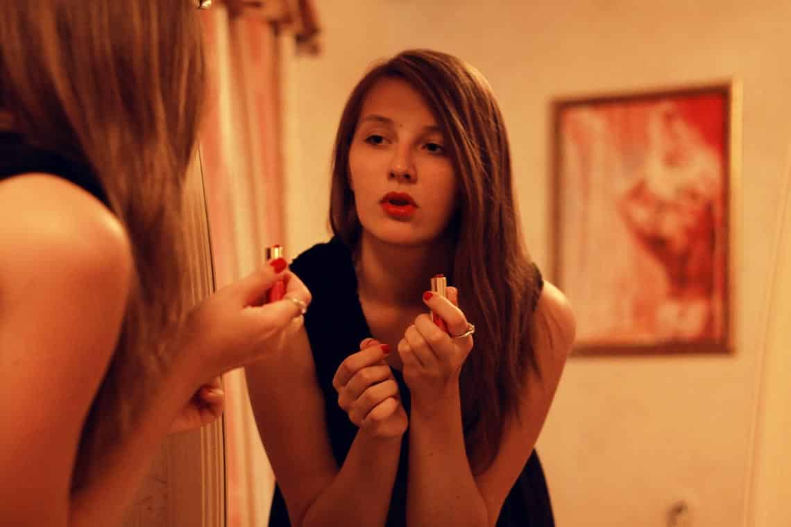 Frau schminkt sich vor dem Spiegel